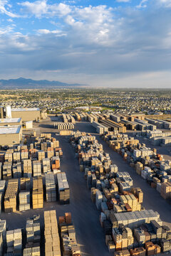 Aerial view of a masonry block loading area with stacks of pavers, retaining wall blocks, and construction materials arranged in rows at a facility in Bluffdale, Utah, United States.