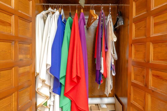 Colorful liturgical vestments hanging in a sacristy closet