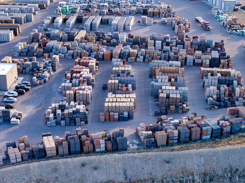 Aerial view of a masonry block loading area with rows of stacked concrete pavers and construction materials in an industrial yard in Bluffdale, Utah, United States.