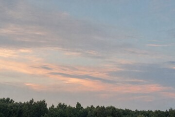 Fototapeta premium Dreamy Summer Sky Over Distant Green Treeline
