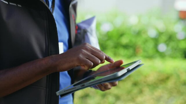 Close-up of a delivery driver using a digital tablet to manage shipments and delivery tasks. Modern logistics and mobile workflow concept.