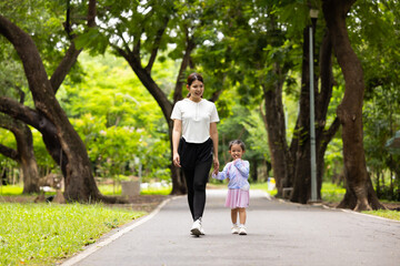 Fototapeta premium Energy, Asian girl and mother running outdoor for child development or growth. Adventure, excited and path with happy kid in nature park for outdoors activity. Healthy outdoor sport for kids.