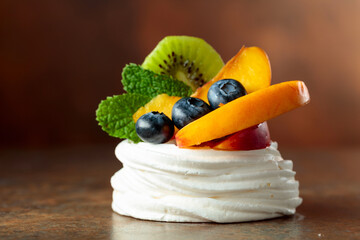 Pavlova dessert with nectarines, kiwis, blueberries, and mint.