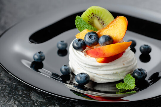 Pavlova dessert with nectarines, kiwis, blueberries, and mint.
