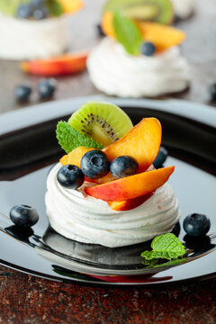 Pavlova dessert with nectarines, kiwis, blueberries, and mint.