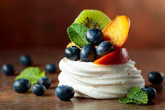 Pavlova dessert with nectarines, kiwis, blueberries, and mint.