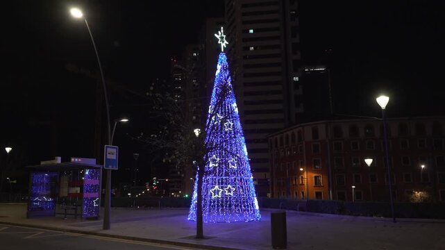 Luminous blue christmas tree decorating bilbao city at night