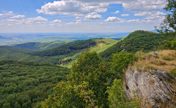 Wide panoramic view from the Őr-kő viewpoint overlooking the forested hills and southern foothills of the B&uuml;kk Mountains under dramatic summer clouds, B&uuml;kk National Park, Hungary.