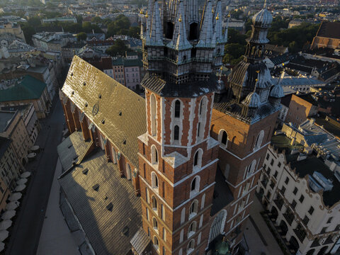 Aerial view of St. Mary's Basilica with its iconic brick towers and gothic architecture, surrounded by historic old town rooftops in Krakow, Malopolskie, Poland.