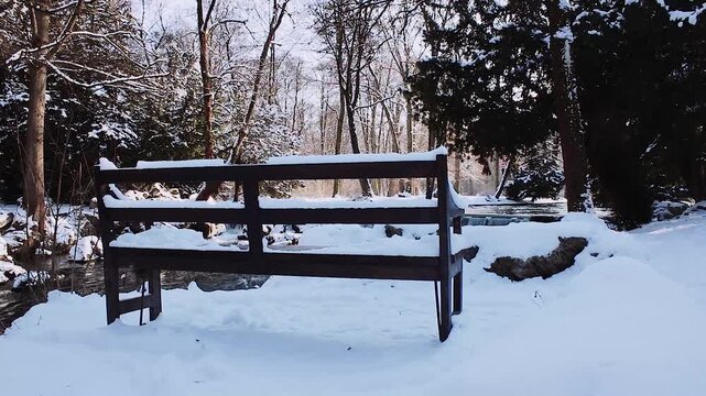 Verschneite Parkbank am Eisbach-Wasserfall im Englischen Garten