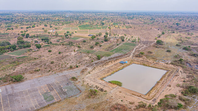 Aerial view of a large rectangular water reservoir surrounded by agricultural plots and dry rural landscape in Kaberamaido, Eastern Region, Uganda.