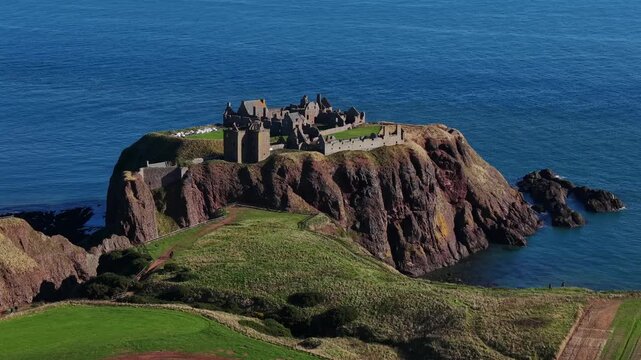 Beautiful cinematic Aerial footage of Dunnottar Castle and Dramatic Cliffs, Stonehaven Scotland &ndash; Historic Medieval Fortress on the North Sea	