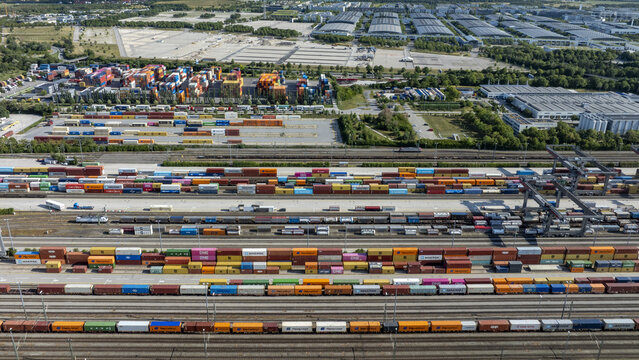 Munich, Germany - 20 July 2026: Aerial view of Container Depot Munchen with rows of colorful shipping containers, freight trains on tracks, and industrial infrastructure.