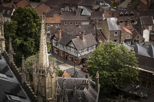 York, United Kingdom - 14 July 2026: Aerial view of the historic city center, featuring the gothic spires of York Minster, traditional timber-framed buildings, and narrow streets with lush trees.