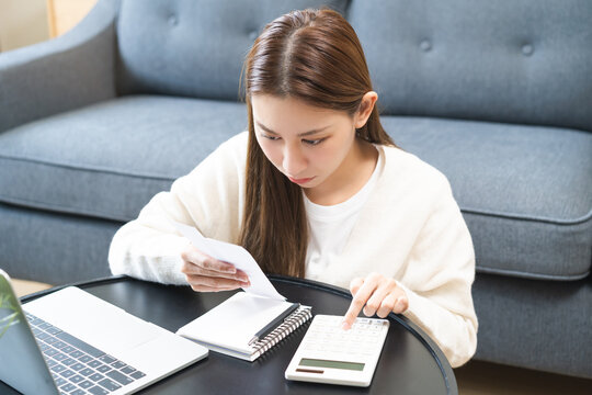 Business financial concept, stressed asian young woman checking list statement of credit card for calculate accounting expense, tax for payment on due deadline, trying to find money to pay debt.