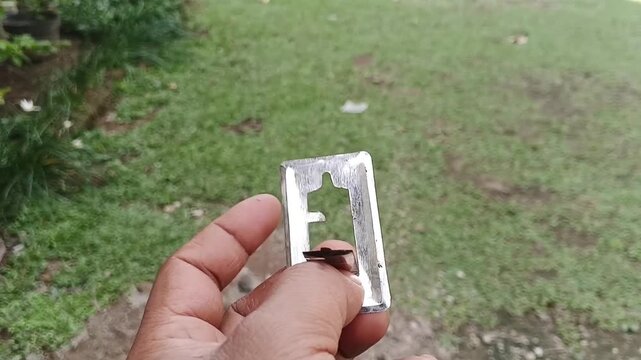 Close Up of Hand Holding A Metal Stand for Mosquito Repellent Coil