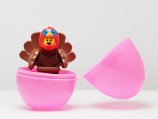 Naklejka premium Indonesia - February 8, 2026 : Mini toy of action figure at outdoor with blur background. Miniature photography concept design. Minifigure of baby chicken character coming out from egg. New born bird