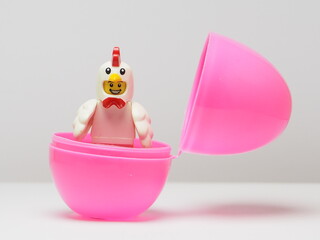 Fototapeta premium Indonesia - February 8, 2026 : Mini toy of action figure at outdoor with blur background. Miniature photography concept design. Minifigure of baby chicken character coming out from egg. New born bird