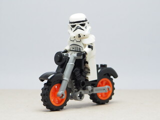 Obraz premium Indonesia - December 5, 2025 : Mini toy of action figure at outdoor with blurred background. Miniature photography concept design. Couple of stormtrooper minifigure character riding motorcyle together
