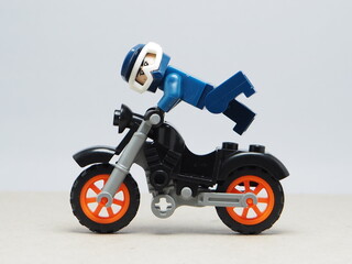 Obraz premium Indonesia - December 5, 2025 : Mini toy of action figure at outdoor with blurred background. Miniature photography concept design. Minifigure of freestyler athlete character jumping with motorcycle.