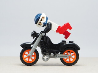 Fototapeta premium Indonesia - December 5, 2025 : Mini toy of action figure at outdoor with blurred background. Miniature photography concept design. Minifigure of freestyler athlete character jumping with motorcycle.