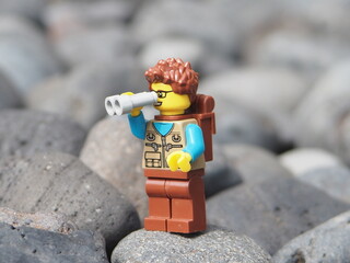 Fototapeta premium Indonesia - January 25, 2025 : Mini toy of action figure at outdoor with blurred background. Toy photography concept design. Minifigure of people character traveling and trekking at mountain