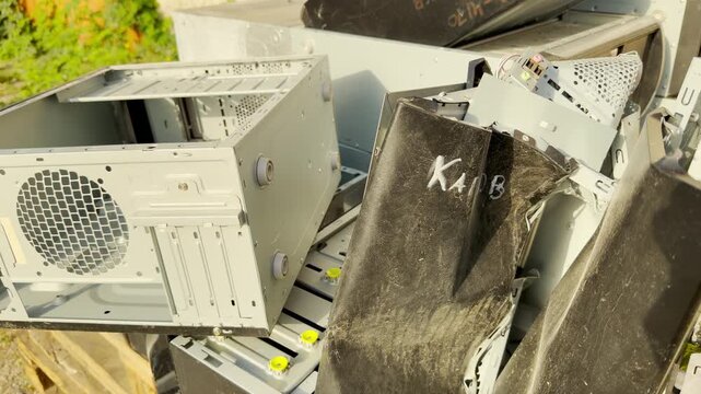 Old computer cases lie discarded on a wooden pallet outdoors. This cluttered pile evokes a sense of forgotten technology and nostalgic, quiet sadness for the past.