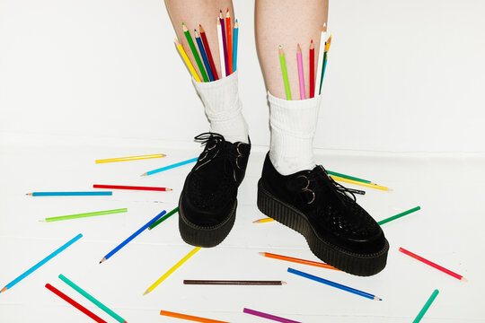 Person wearing fashion style shoes & sock full of colour art pencils