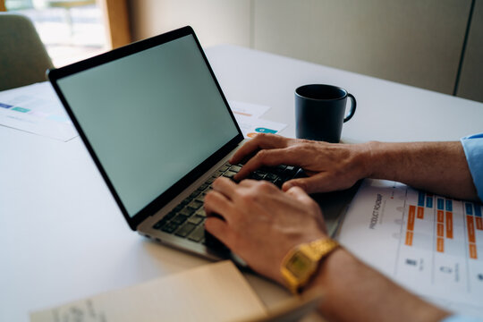A man using a laptop with a white screen