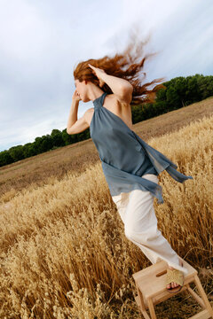 Woman with red hair enjoying freedom in field