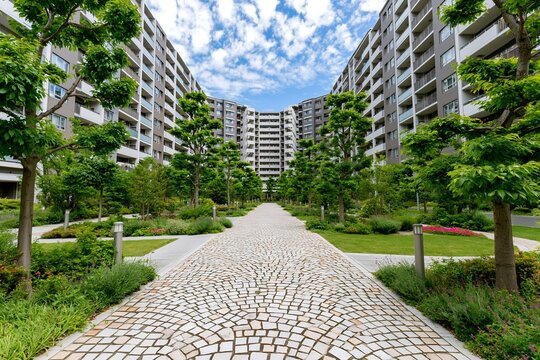 石畳の通路が続く都会のマンション群と美しい中庭