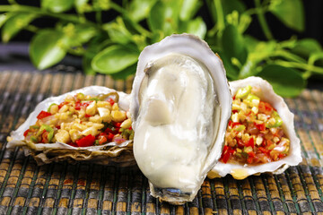 Fresh Raw Oysters with Colorful Vegetable Garnish on Bamboo Mat Studio Food Photography © VuVan