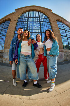 Group of friends posing outside a modern building in the city