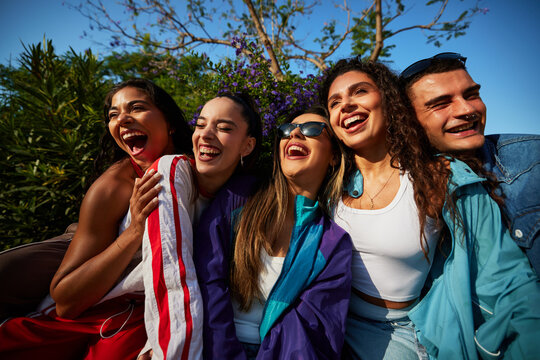 Group of friends having fun outdoors in bright sunlight
