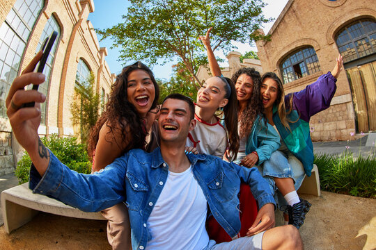 Group of friends taking selfie outside near building