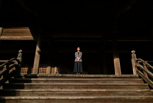 Ancient Japanese Temple Hall and Professional Woman at Sunset.