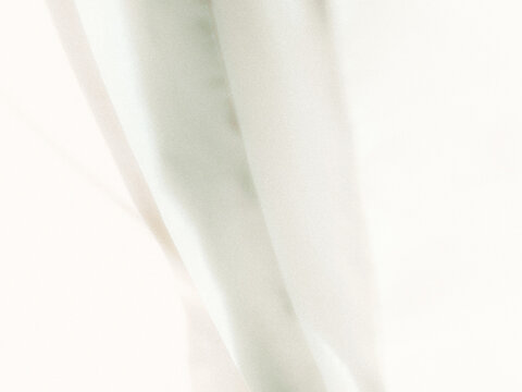 Soft white fabric folds creating an abstract minimalist background with subtle shadows and gentle curves, suitable for elegant product photography, branding, packaging, and graphic design.
