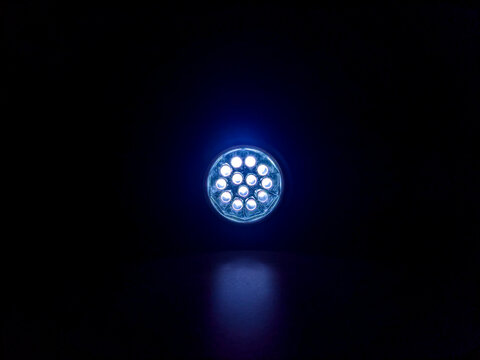 Flashlight beam shining in a dark room, creating a focused light spot and strong contrast, highlighting visibility, direction, and minimal illumination in a low-light environment.