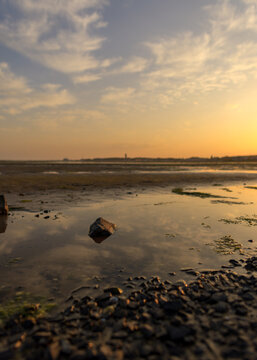 Romantic soft focus image at the harbor of Terschelling at ebb tide during sunset