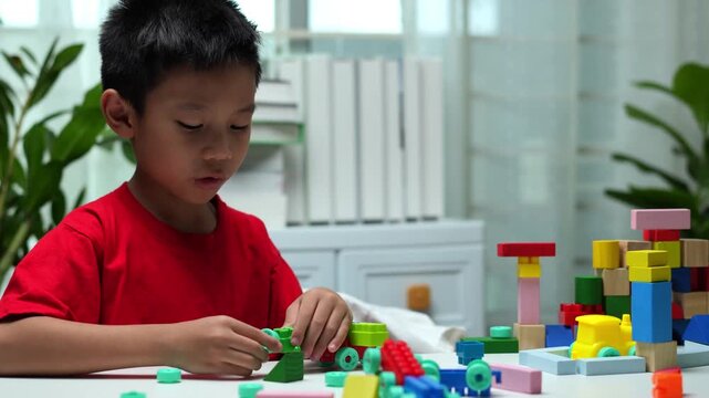 Two young children playing with colorful building blocks at home, encouraging teamwork, creativity, problem solving, fine motor skills, and early childhood learning in a bright educational environment