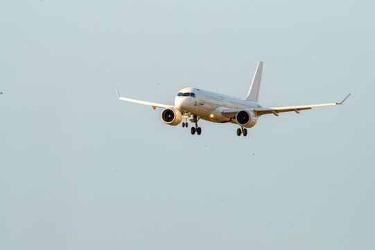 An airliner approaches the runway with its landing gear down at Brussels Airport in Belgium, the jet on short final in warm evening light.
