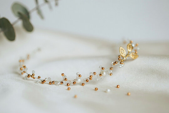 An elegant delicate handcrafted hair accessory headband adornment featuring shimmering golden leaves lustrous small white pearls and sparkling copper beads intricately woven on a fine flexible wire