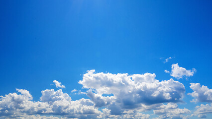 horizontal strip of white clouds stretched under a clear blue dome © Родион Бондаренко