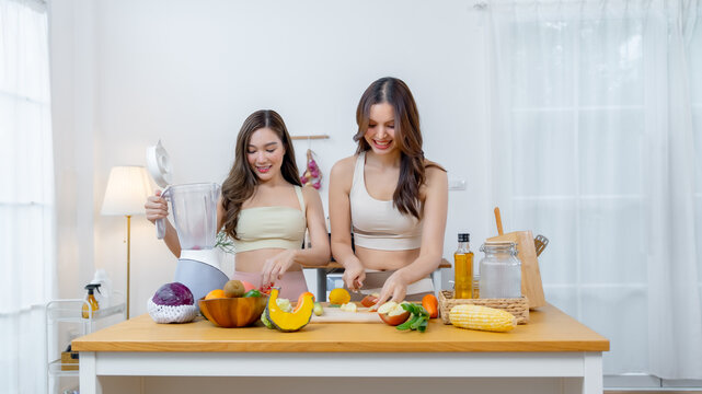 Active women enjoying meal preparation with fresh produce and natural ingredients highlighting fitness healthy cooking self care nutrition and modern lifestyle with copy space.