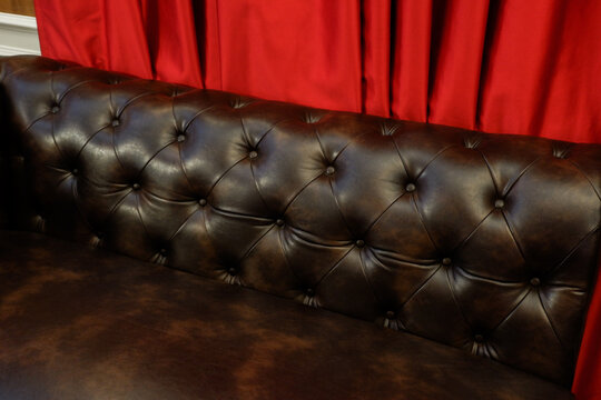 Black soft leather luxurious sofa in living room with curtain red,mock up interior in classic style, modern interior design concept.