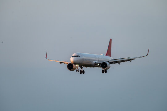 An airliner descends on final approach against a soft grey sky at Brussels Airport in Belgium, the jet on short final to the runway.