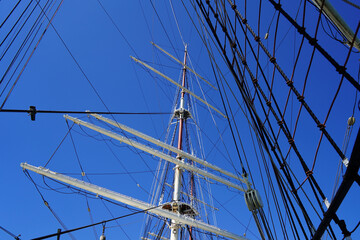 Ship masts and intricate rigging against a clear blue sky © Yordan Balabanov