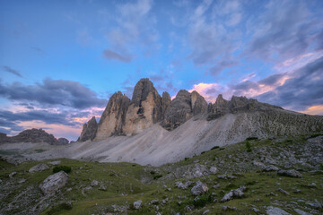 A stunning wide-angle view of Tre Cime di Lavaredo in the Italian Dolomites during a colorful sunset, perfect for travel and nature themes. © marcodenaro