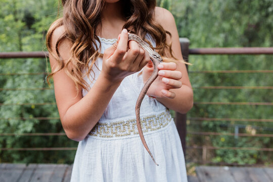 girl holding a snake outdoors 