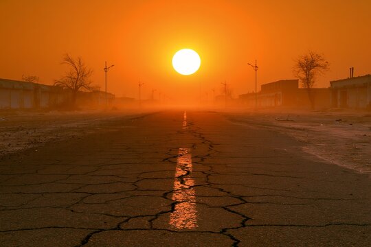 沈みゆく夕日が照らすひび割れた道終末の光景